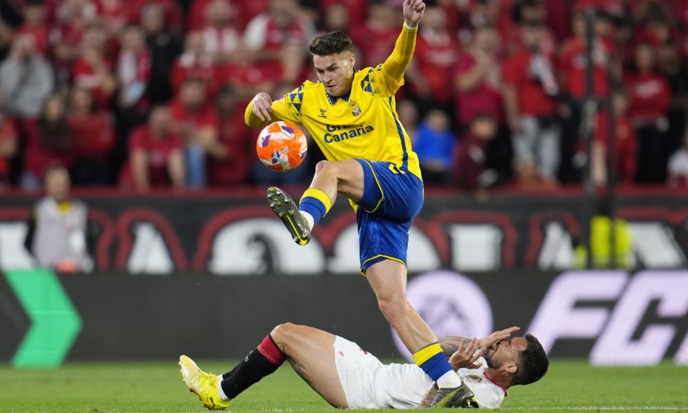 SEVILLE, SPAIN - MAY 13: Mika Marmol of UD Las Palmas controls the ball whilst Suso of Sevilla FC goes to ground holding his face during the LaLiga match between Sevilla FC and UD Las Palmas at Estadio Ramon Sanchez Pizjuan on May 13, 2025 in Seville, Spain. (Photo by Aitor Alcalde/Getty Images)
